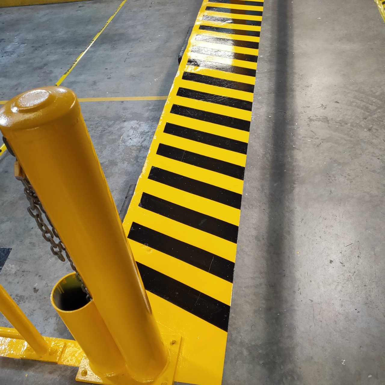 Loading dock edge with hazard striping and caution barrier
