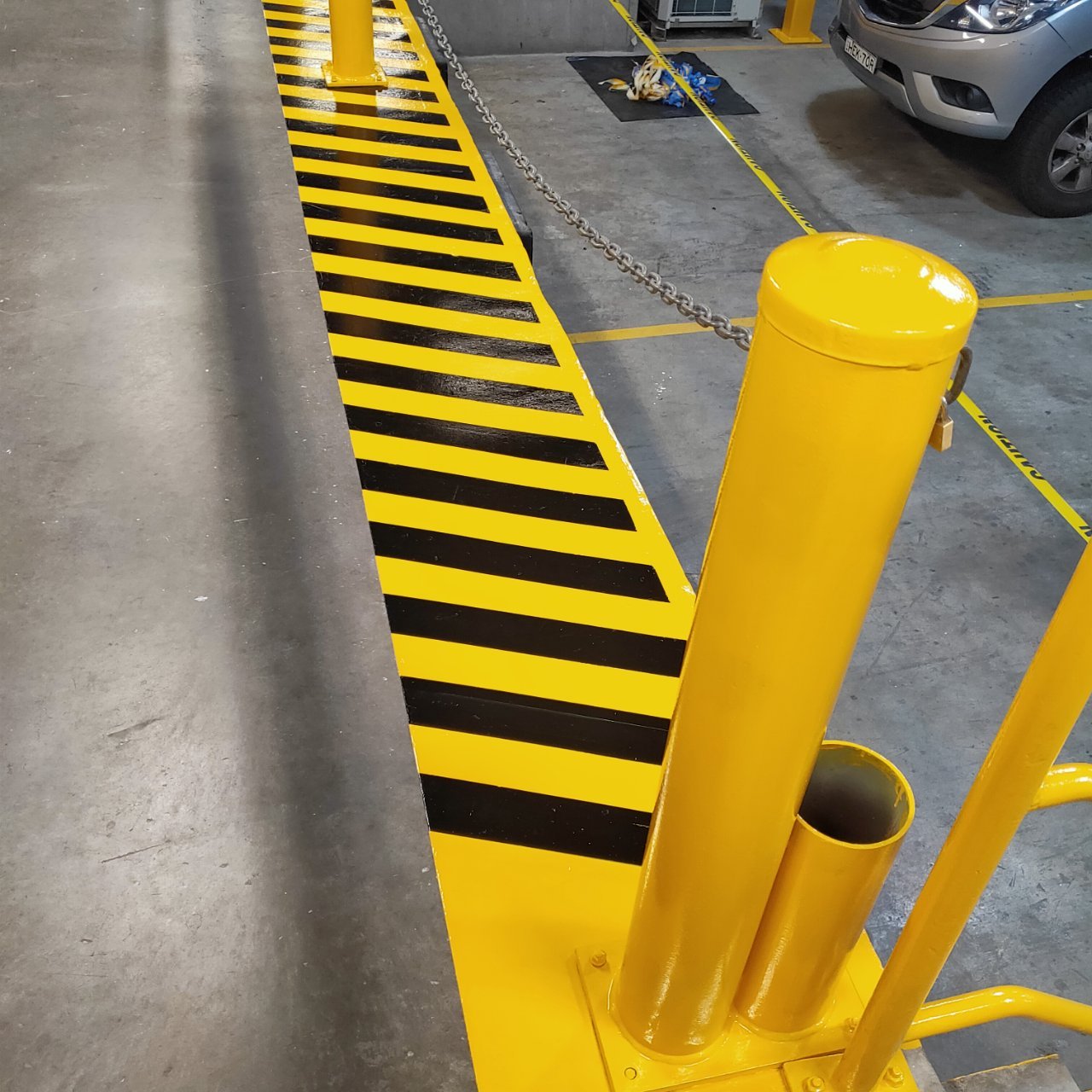 Yellow bollard and black-and-yellow striped kerb