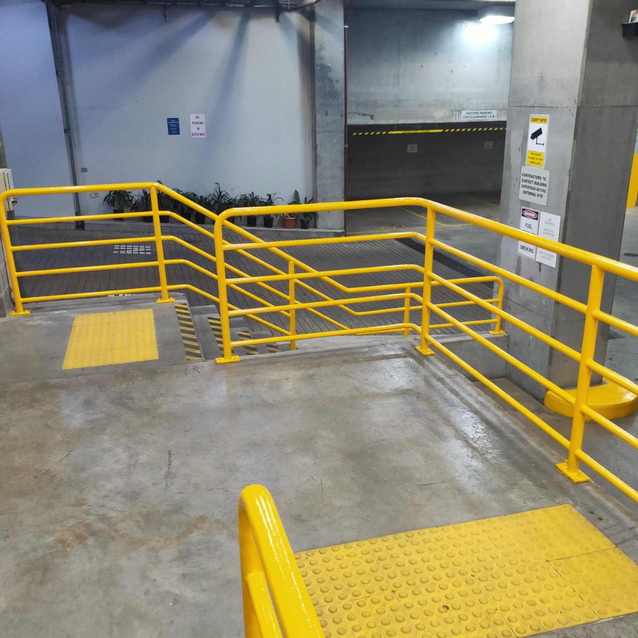 Yellow safety handrails on a car park ramp